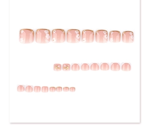 Détail de faux ongles de pieds dégradé rose avec fleurs blanches et perles élégantes
