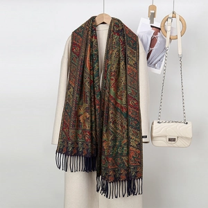 Detailed paisley pattern winter scarf with fringes styled on a beige coat and handbag