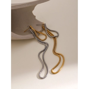 Macro detail of 18k gold and silver snake bone chain drop earrings on stone props