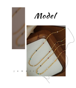 Detailed macro view of minimalist gold-plated titanium necklace with colorful enamel beads