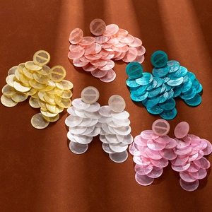 Detail of five colorful resin shell disc tassel earrings in tiered circular design