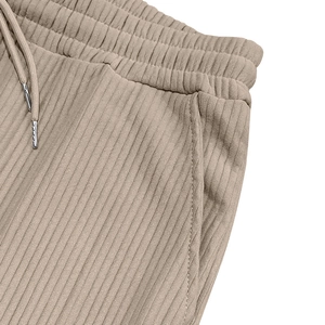 Detail of apricot corduroy joggers showing elastic waistband with metal tip drawstring