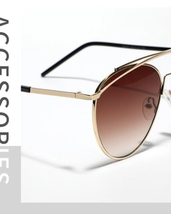Macro detail of aviator sunglasses showing gold metal frame and brown gradient lenses