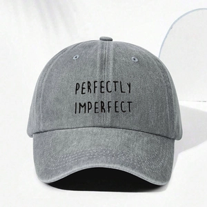 Detail of embroidered Perfectly Imperfect text on washed gray denim baseball cap