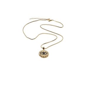 Macro detail of gold evil eye pendant with colored stones and black enamel inlay