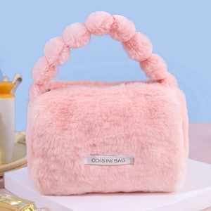Pink plush cosmetics bag with pom-pom handles for high-capacity travel storage