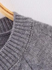 Macro detail of ribbed crew neck collar on a gray knitted cardigan sweater