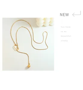 Detail of 18k gold plated snake chain necklace with irregular link and spherical pendant
