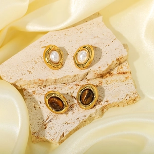 French vintage 18K gold earrings set with natural pearl and tiger eye on travertine