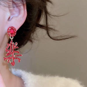 Detailed close-up of a red rhinestone earring featuring the Chinese character for Joy