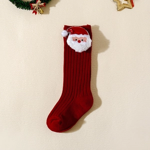 Detail of red ribbed Christmas baby socks featuring a plush Santa Claus 3D appliqué
