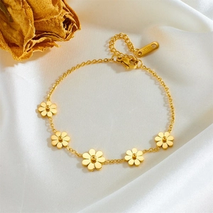 Elegant gold daisy flower chain bracelet made of stainless steel on white silk