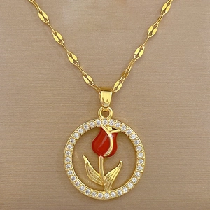 Detailed macro view of a gold circular necklace featuring a red tulip with sparkling zircon