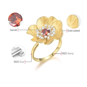 Macro view of gold-plated S925 silver flower ring with a garnet stone and hallmark