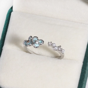 Detail of adjustable silver ring with blue enamel flowers, pearls, and zircons