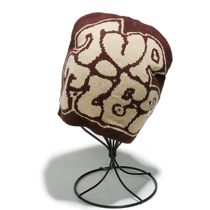 Détail du motif en tricot jacquard marron et beige et lettrage artistique sur le bonnet