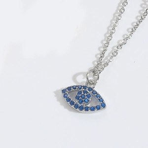 Macro detail of silver evil eye necklace pendant featuring blue zircon pavé setting
