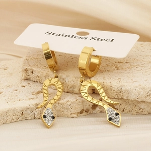 Gold snake earrings in stainless steel with rhinestones on a stone display stand