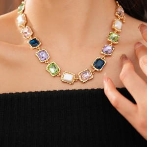 Close-up of vintage gold necklace with multi-color rectangular crystals on woman's neck