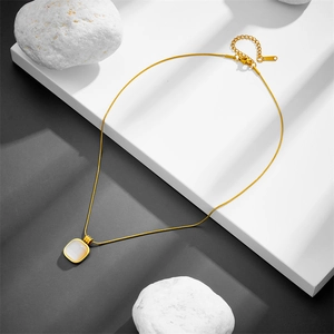Minimalist titanium steel gold necklace with a square cat eye stone pendant on white steps