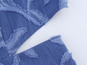 Gros plan du tissu jacquard en jean bleu avec bords effilochés et détails de tissage