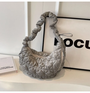 Detailed view of grey quilted moon bag with ruched strap and soft fabric texture