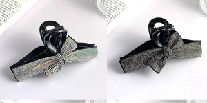 Detail of elegant black hair claws with shimmering rhinestones in bow design