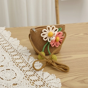 Detailed macro of woven straw bag featuring 3D crochet flowers and metal zipper closure