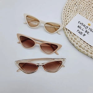 Flat lay of retro cat eye sunglasses in white, brown and nude on white background