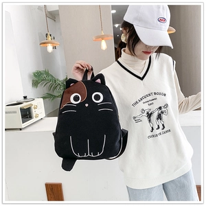 Detail of creative black cat backpack with 3D ears and white embroidery on canvas