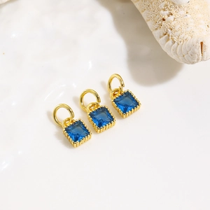 Macro shot of three geometric square blue zircon pendants with 18k gold plated brass finish