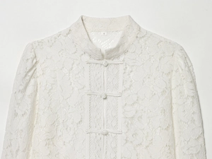 Detail of white lace shirt showing mandarin collar and traditional Chinese frog buttons
