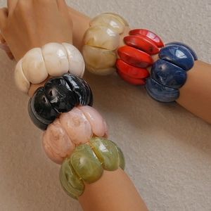 Stacked colorful chunky acrylic link bracelets featuring marble and agate texture patterns