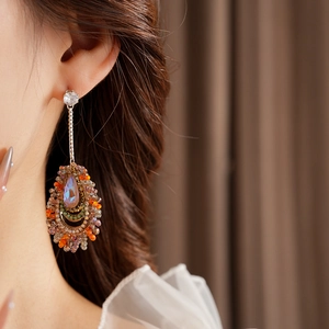 Macro shot of bohemian drop earrings with colorful beads and iridescent crystals