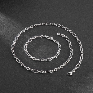 Ensemble collier et bracelet en acier inoxydable argenté de style hip-hop sur fond noir