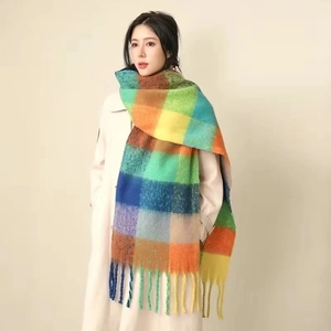 Close-up of soft rainbow plaid mohair scarf with tassels on a female model
