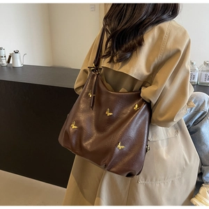 Detail of dark brown PU leather hobo bag featuring 3D golden butterfly ornaments