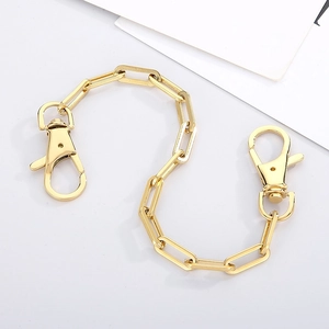 Detailed macro view of golden stainless steel paperclip chain with double lobster clasps