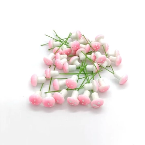 Pink miniature mushroom ornaments with white dots and green wire stems for DIY decor