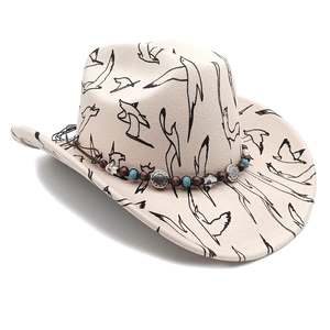 Detailed view of beige western cowboy hat with bird prints and ethnic beaded charm band