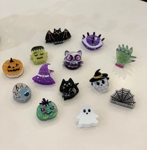 Detailed close-up of 13 colorful Halloween acetate hair clips featuring pumpkin and ghost