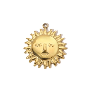 Macro shot of gold sun face pendant with detailed rays and polished metallic finish