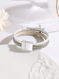 Detailed macro view of white leather multi-layer bracelet with silver magnetic closure