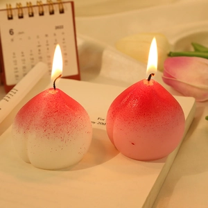 Realistic peach shaped scented candles in pink and white set on an open book