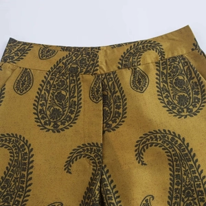 Gros plan de la taille et du motif cachemire sur l'ensemble en satin jaune moutarde