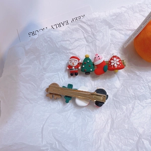 Set of cartoon Christmas hair clips featuring Santa Claus and tree designs on gold clip