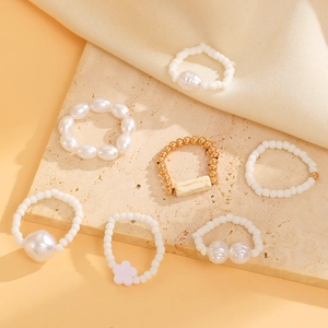 7-piece bohemian pearl ring set with turquoise and gold beads on elegant satin background