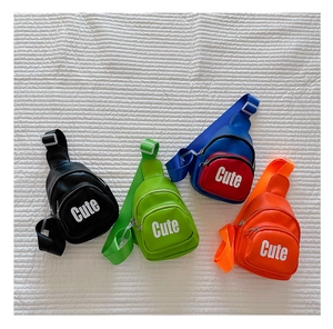 Flat lay of four colorful PU leather kids chest bags in black, green, blue and orange