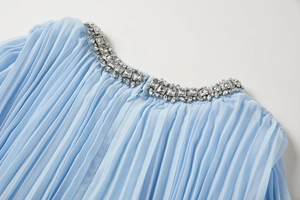 Détail de l'encolure en mousseline plissée bleu clair avec perles et cristaux élaborés