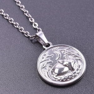 Macro shot of silver fox and crescent moon embossed pendant on metal chain necklace